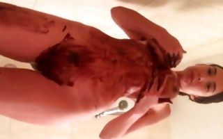 Pretty seductive brunette covers with dirt and washes her big tits